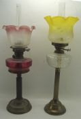 Two Victorian oil lamps, both with brass columnal stands and circular bases,