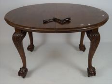 A late 19th/early 20th century oval mahogany extendable dining table on carved cabriole legs with
