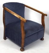 An early/mid century low upholstered armchair, with Arts and Crafts styling,