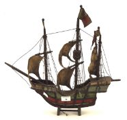 A model of a three mast ship, the wooden boat complete with sails, flags, ropes and painted details,