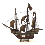 A model of a three mast ship, the wooden boat complete with sails, flags, ropes and painted details,