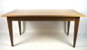 A contemporary wooden dining table, of rectangular form, on tapered square supports,