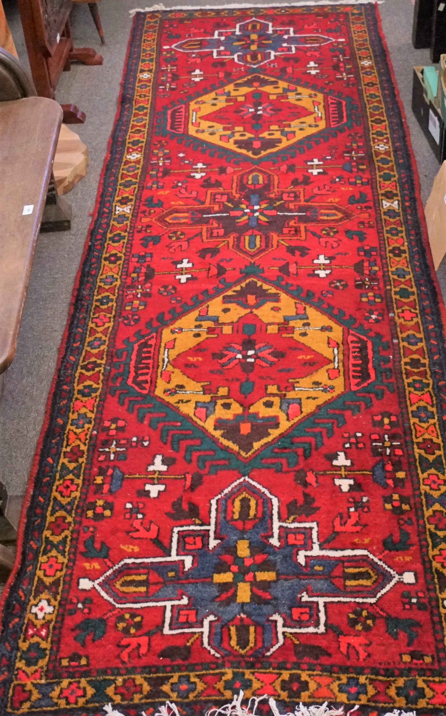 An Azari Persian carpet, the rug featuring five geometric medallions on a red ground,
