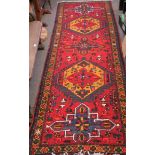 An Azari Persian carpet, the rug featuring five geometric medallions on a red ground,