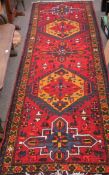 An Azari Persian carpet, the rug featuring five geometric medallions on a red ground,