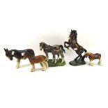 Four ceramic horses and a donkey, including a Beswick model of a rearing horse