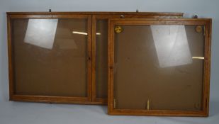 Two oak framed glazed advertising wall cabinets, one with lockable double doors,