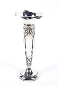 An early 20th century silver spill vase, decorated with floral motifs,