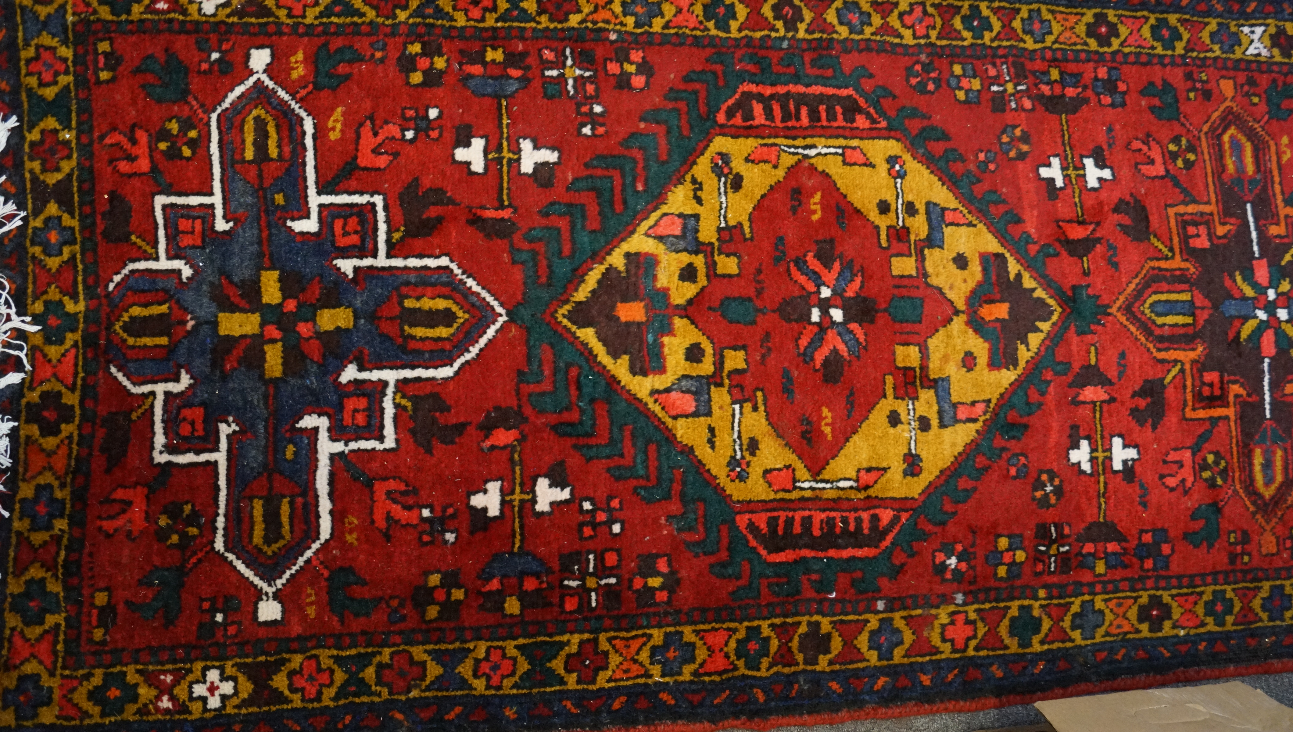 An Azari Persian carpet, the rug featuring five geometric medallions on a red ground, - Image 2 of 2