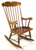 A contemporary wooden rocking chair, with spindle back and turned supports,