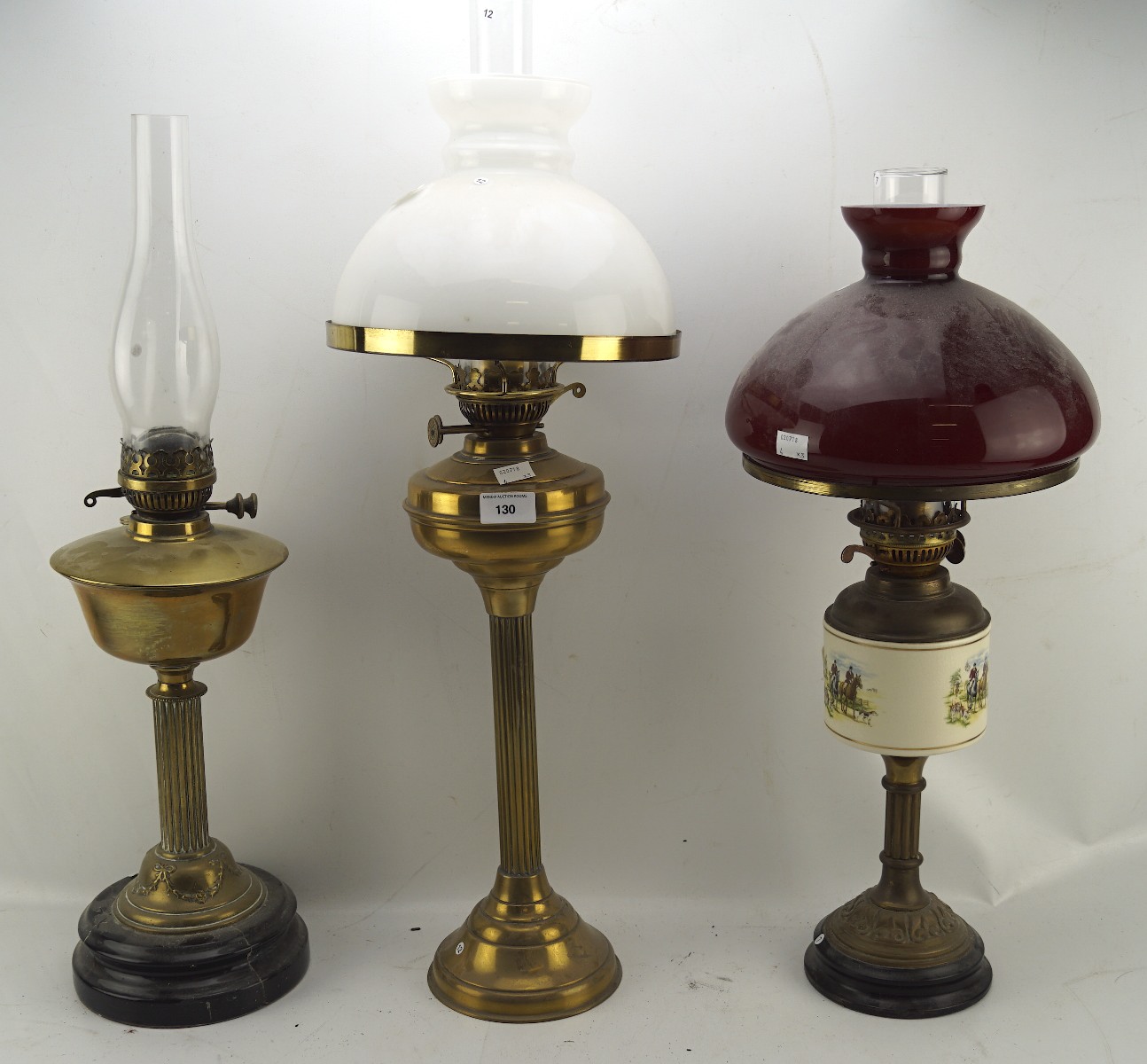 Three Victorian oil lamps, all with brass column frames on circular bases,