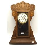 A 20th century carved wooden mantle clock, the dial with Roman numerals denoting hours,