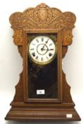 A 20th century carved wooden mantle clock, the dial with Roman numerals denoting hours,