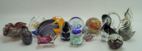 A collection of vintage and modern glass paperweights, glass sculptures and an ashtray,