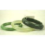 Two Chinese Jadeite bangles and a similar hard stone example,