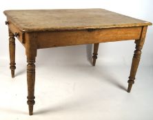 A pine kitchen table, with curved edges and a single drawer to one end,