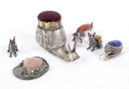 A selection of white metal novelty pin cushions,