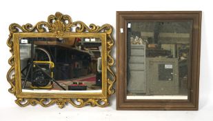 Two early 20th century wall mirrors, one in ornate gilt frame, the other stained wood,