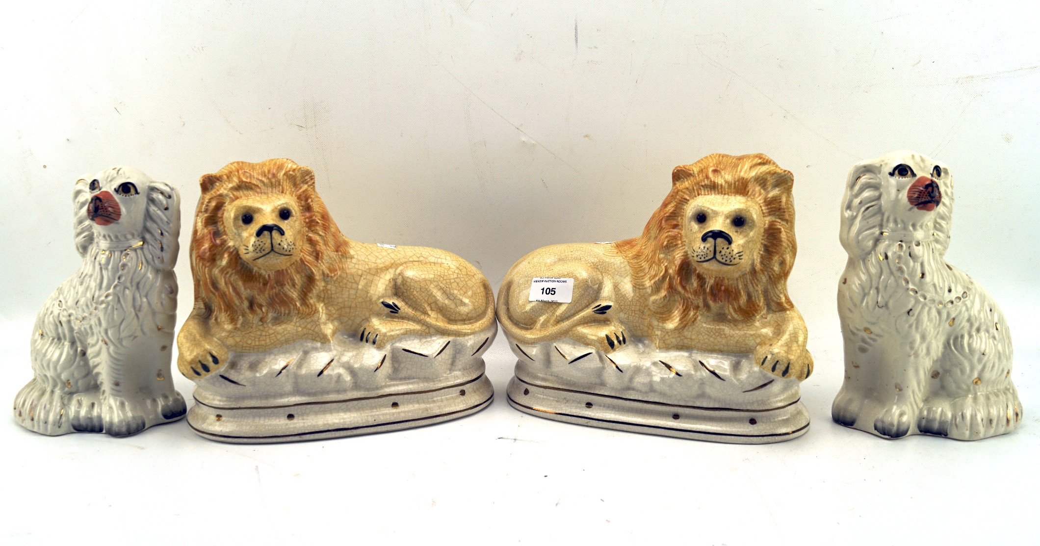 A pair of reproduction Staffordshire lions and a pair of spaniels,