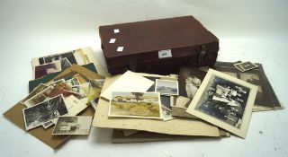 A collection of 20th century black and white photographs in a vintage leather carry case
