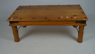 A contemporary pine coffee table with metal studs and details, on turned legs,