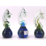 A group of three Mdina glass paperweights, all modelled as seahorses, in blue and green,