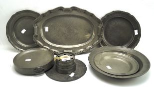 A collection of pewter, including shaped trays, plates and a dish