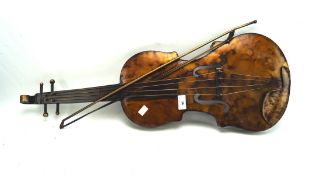 A contemporary metal wall hanging in the form of a violin, together with a matching bow,