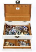 A vintage jewellery box containing a selection of costume jewellery,