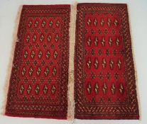 A small pair of Turkoman rugs with geometric patterns on a red ground