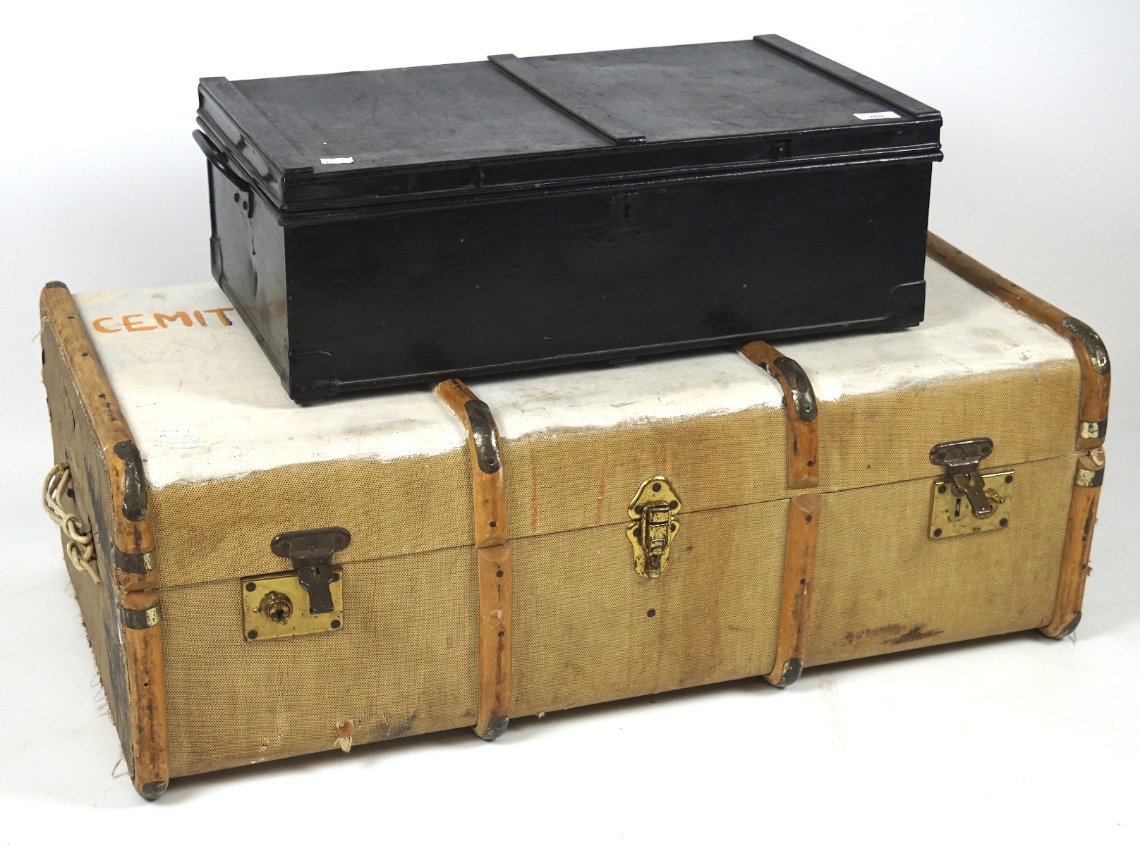A mid-century canvas trunk and a smaller metal example, the first with wood banding,