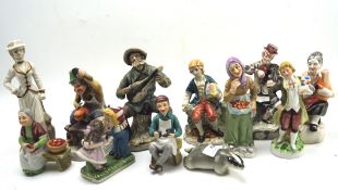 A collection of ceramic figures, each depicting people in traditional dress,