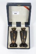 A pair of miniature urns decorated with Egyptian Gods complete with socles, 10cm high,