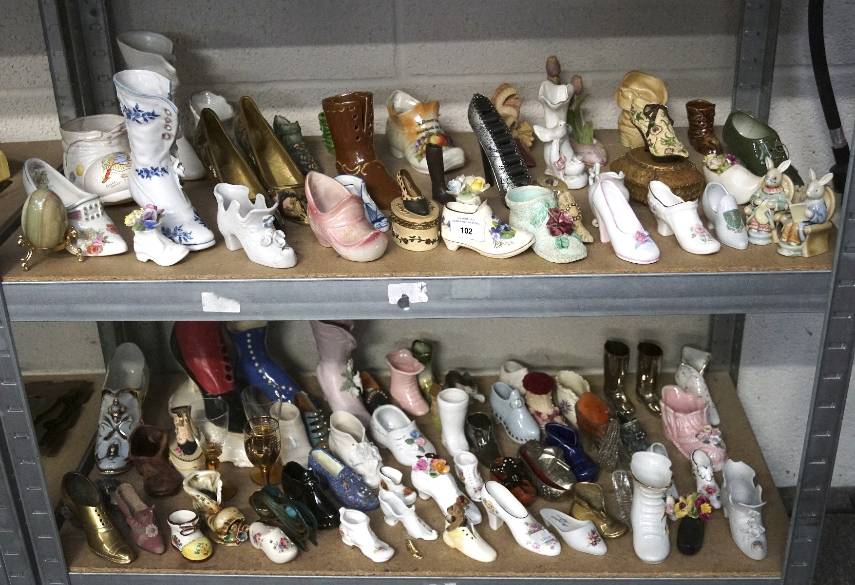 A large collection of ceramic and pottery shoe and boot ornaments,