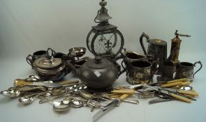 A collection of silver plate and metalware, including flatware, a pepper grinder, teapots,