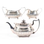 A George III three piece silver tea set, each with half gadrooned bodies raised upon four feet,