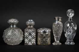 A collection of five silver topped cut glass bottles, including one of globular form,