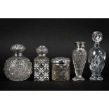 A collection of five silver topped cut glass bottles, including one of globular form,
