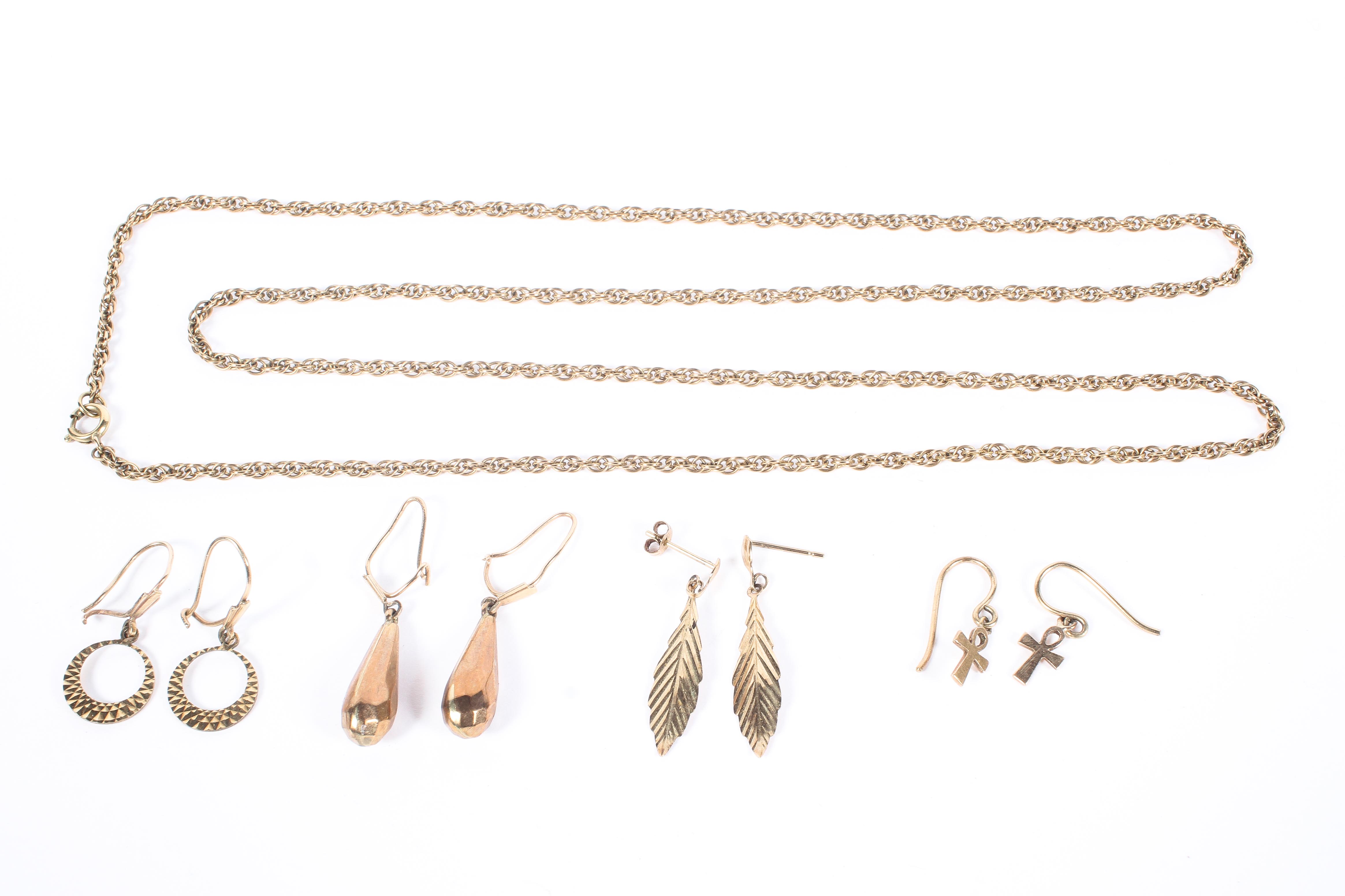 A collection of unmarked yellow metal jewellery items to include earrings and a chain link necklace.