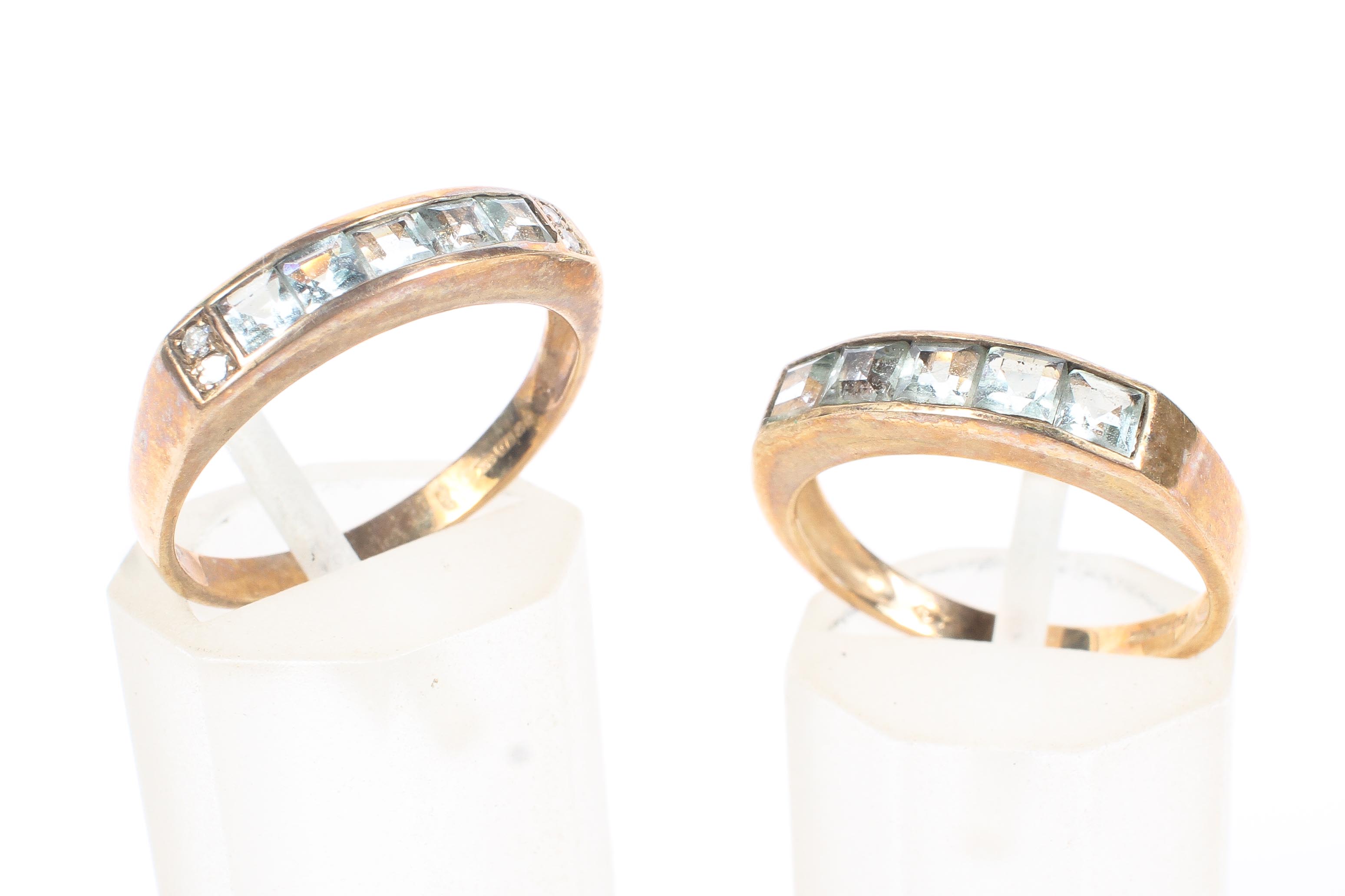 Two 9ct gold and aquamarine half eternity rings, each set with a line of princess cut aquamarines,