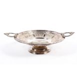 A silver plated circular footed dish with loop handles and repousse decoration,