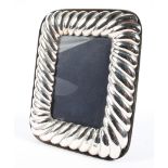 A vintage silver picture frame, with rounded corners and reeded design, hallmarked London 1988,