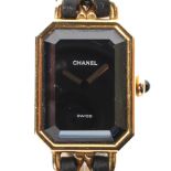 A lady's gold plated quartz watch marked 'Chanel', black dial with gilt hands,