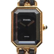 A lady's gold plated quartz watch marked 'Chanel', black dial with gilt hands,