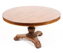 A Victorian rosewood round tilt topped breakfast table raised on carved tulip ballester shaped