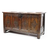 An 18th century oak coffer with craved front panels and frieze,