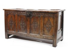 An 18th century oak coffer with craved front panels and frieze,