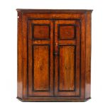 A Georgian oak two door inlaid corner cupboard,