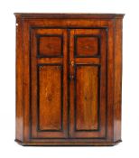 A Georgian oak two door inlaid corner cupboard,