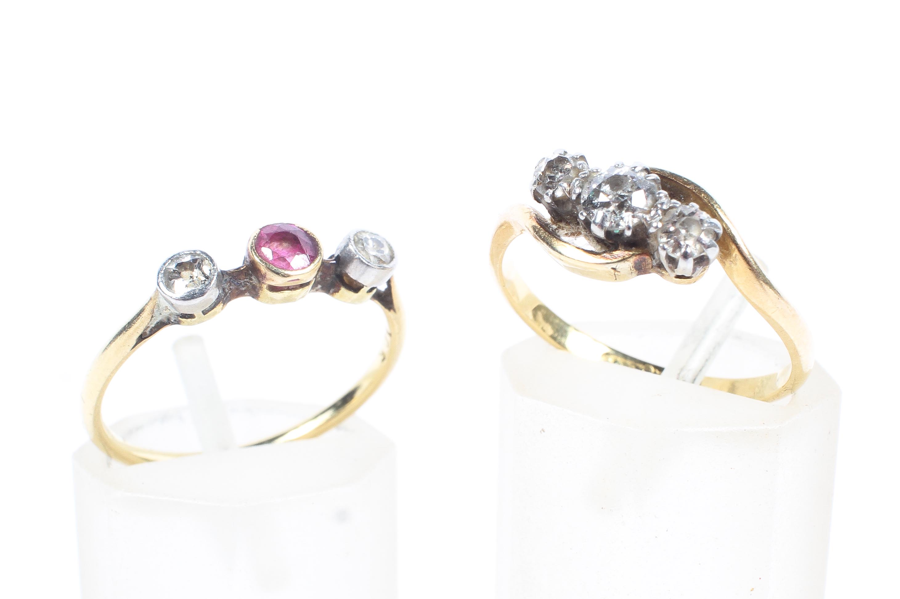 An 18ct gold and diamond three stone ring together with a 9ct ruby ring with diamond accents,